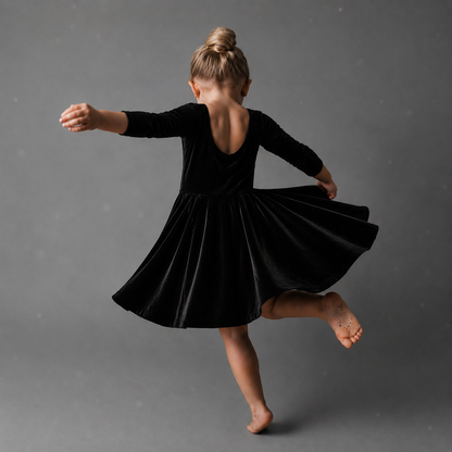 girl twirling in black velvet dress with 3/4 length sleeves